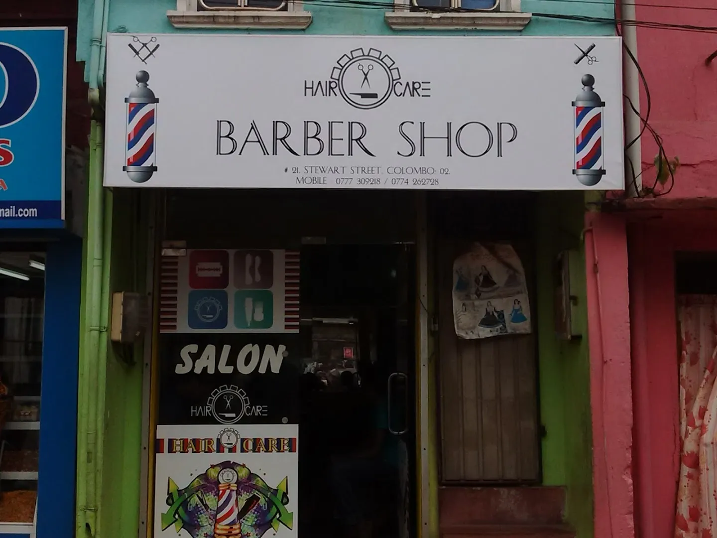 Hair Care Barber Shop storefront on Stewart Street, Colombo 02, with the white BARBER SHOP fascia and twin red-white-blue barber poles